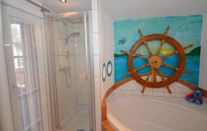 ein Badezimmer mit einer Badewanne mit einem Rad an der Wand in der Unterkunft Ferienwohnung Traumschiff in Erzingen