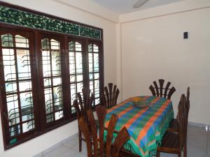 a dining room with a table and chairs and windows at Ceylon Epic Inn in Bentota