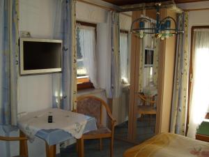 a bedroom with a bed and a tv on a wall at Pension Herzoghäusel in Bischofswiesen +33 photos