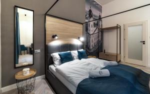 ein Schlafzimmer mit einem großen Bett und einem Spiegel in der Unterkunft Catalog Boutique Rooms in Debrecen