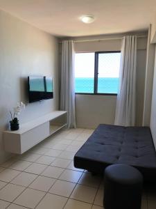 um quarto com uma cama e uma televisão de ecrã plano em Apartamento 02 quartos completo, BEIRA-MAR com piscina em Maceió