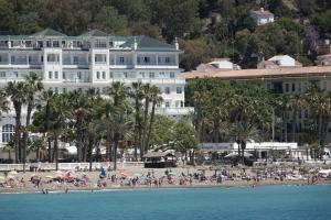 een groep mensen op een strand met gebouwen bij THE PHOTOGRAFIC LOFT in Málaga