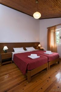 a bedroom with a large bed with a red blanket at Villa Bacchus Kassiopi Corfu in Kassiopi