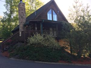a log cabin with a porch and a balcony at Southern Grace in Sevierville