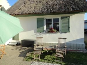 two chairs and a table in front of a house at Cottage Ferienwohnung mit Seeblick in Caputh