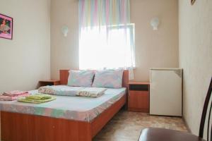 a small bedroom with a bed with a window at Hotel Kings Zatoka in Zatoka
