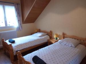 une chambre avec deux lits et une fenêtre dans l'établissement "Les Mouettes" Maison de pêcheur en centre ville, à Saint-Vaast-la-Hougue