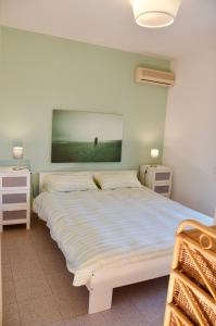 ein Schlafzimmer mit einem Bett und zwei Nachttischen in der Unterkunft BeachFront Rooms Marina di Ragusa in Marina di Ragusa