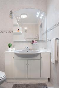 Baño blanco con lavabo y espejo en Home Sweet Home en Ílhavo