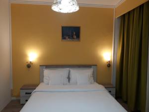 1 dormitorio con 1 cama blanca grande y 2 lámparas en Pensiunea Sydney, en Timisoara