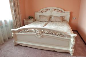 a bedroom with a white bed with a white headboard at ApartHotel na Berezovoy in Zelenaya Polyana