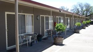 un edificio con mesas, sillas y plantas. en Augusta Courtyard Motel, en Port Augusta