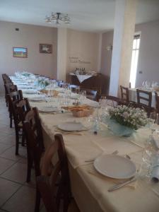 PeveragnoにあるCiabot Besimaudaの白皿と花の長いテーブル