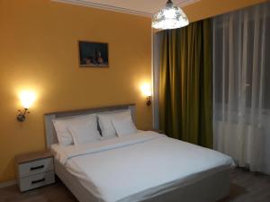 a bedroom with a large white bed and a window at Pensiunea Sydney in Timişoara