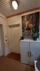 a room with a painting of a deer on the wall at 4 Sterne Wohnen "Zum alten Forsthof" am Schlosspark, App 3 "wunnerbor" in Eutin