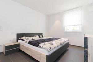 a bedroom with a large bed in a white room at Appartement Neuenstadt in ruhiger Lage im Wohngebiet in Neuenstadt am Kocher