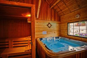 a jacuzzi tub in a wooden room with a window at Hôtel & Spa La Ferme de l'Izoard in Arvieux