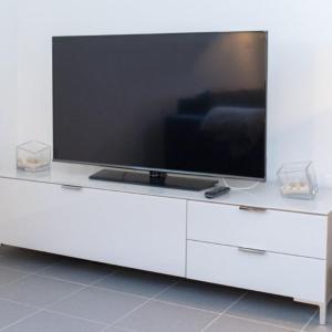 einen großen Flachbild-TV auf einem weißen Entertainment-Center in der Unterkunft Appartement Neuenstadt in ruhiger Lage im Wohngebiet in Neuenstadt am Kocher