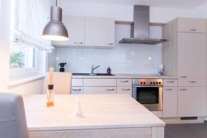 eine Küche mit weißen Schränken und einer weißen Arbeitsplatte in der Unterkunft Appartement Neuenstadt in ruhiger Lage im Wohngebiet in Neuenstadt am Kocher