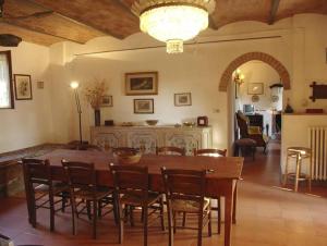 un comedor con una gran mesa de madera y sillas en Villa Casalunga, en Buonconvento