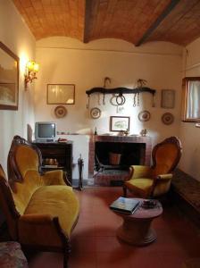 sala de estar con sillas y chimenea en Villa Casalunga, en Buonconvento
