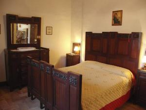 1 dormitorio con cama, tocador y espejo en Villa Casalunga, en Buonconvento