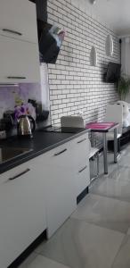 a kitchen with white cabinets and a pink table at Апартаменты. Холодная гора, ул. Дудинской 1а. in Kharkiv +2 photos