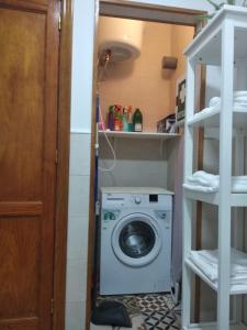 uma lavandaria com uma máquina de lavar roupa num quarto em Mary's Home em Moya