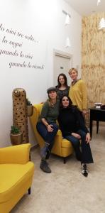 a group of people sitting on a yellow couch at B&B iMori in Caltagirone