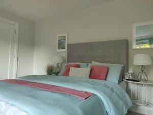 a bedroom with a large bed with colorful pillows at Apartment in Letterkenny