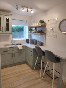 a kitchen with green cabinets and a table with chairs at Apartment in Letterkenny