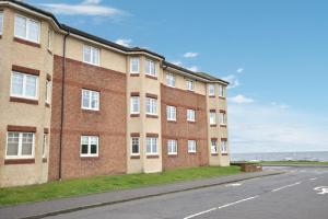 a large brick building on the side of a street at Wood Court, Troon in Troon