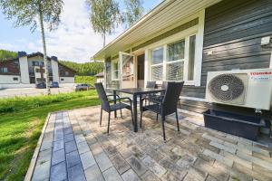 eine Terrasse mit einem Tisch und Stühlen sowie einem Ventilator in der Unterkunft Apartments Huili in Tahkovuori