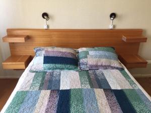1 cama con cabecero de madera y 2 almohadas en Acogedor depto en condominio Algarrobo, en Algarrobo