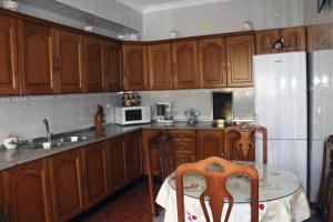a kitchen with wooden cabinets and a table and a refrigerator at Casa juan in Algodonales