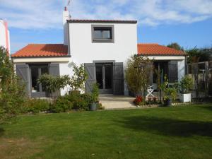uma casa branca com um telhado vermelho e um quintal em Chambre d'Hôtes aux Sables d'Olonne em Les Sables-dʼOlonne