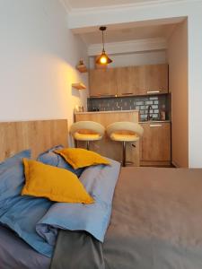Habitación con cama con almohadas amarillas. en Cosy Apartment, en Borjomi