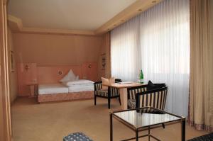 een woonkamer met een bed en een tafel en stoelen bij Hotel Cafe Leda in Haigerloch