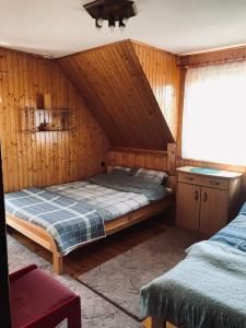 - une chambre avec un lit dans un mur en bois dans l'établissement DOM NaD JEZIOREM, à Krasnogruda