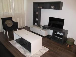 a living room with a white coffee table and a television at Apartment Ivi034 Kragujevac in Kragujevac