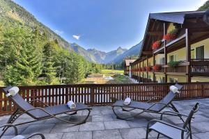 two chairs on a patio with a view of mountains at Elements Hotel Christlessee in Oberstdorf
