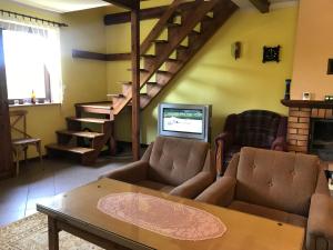 a living room with a couch and a table and a tv at DOM NaD JEZIOREM in Krasnogruda