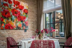 a table in a restaurant with a painting on the wall at Hostellerie Schuddebeurs in Schuddebeurs