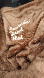 una manta marrón con las palabras controladas estudio escrito en ella en DOURADOS GUEST FLAT HOUSE, en Dourados