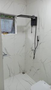 ドウラドスにあるDOURADOS GUEST FLAT HOUSEの白いバスルーム(シャワー、トイレ付)
