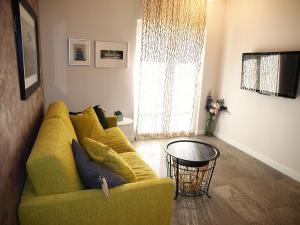 a living room with a yellow couch and a table at Apartments House Filipović in Makarska
