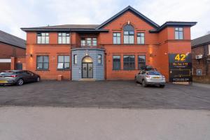 a house with two cars parked in a parking lot at 42 Apart-Hotel in Scunthorpe