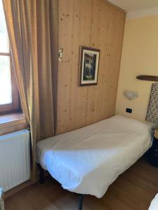 Bett in einem Zimmer mit einer Holzwand in der Unterkunft Chalet montagna e relax Volpe Rossa in Cavalese