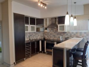 a kitchen with black and white cabinets and a counter at Whale Rock in Margate