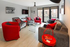 uma sala de estar com um sofá e cadeiras vermelhas em Centrally located apartment in Duke Street- free parking- two bathrooms em Liverpool